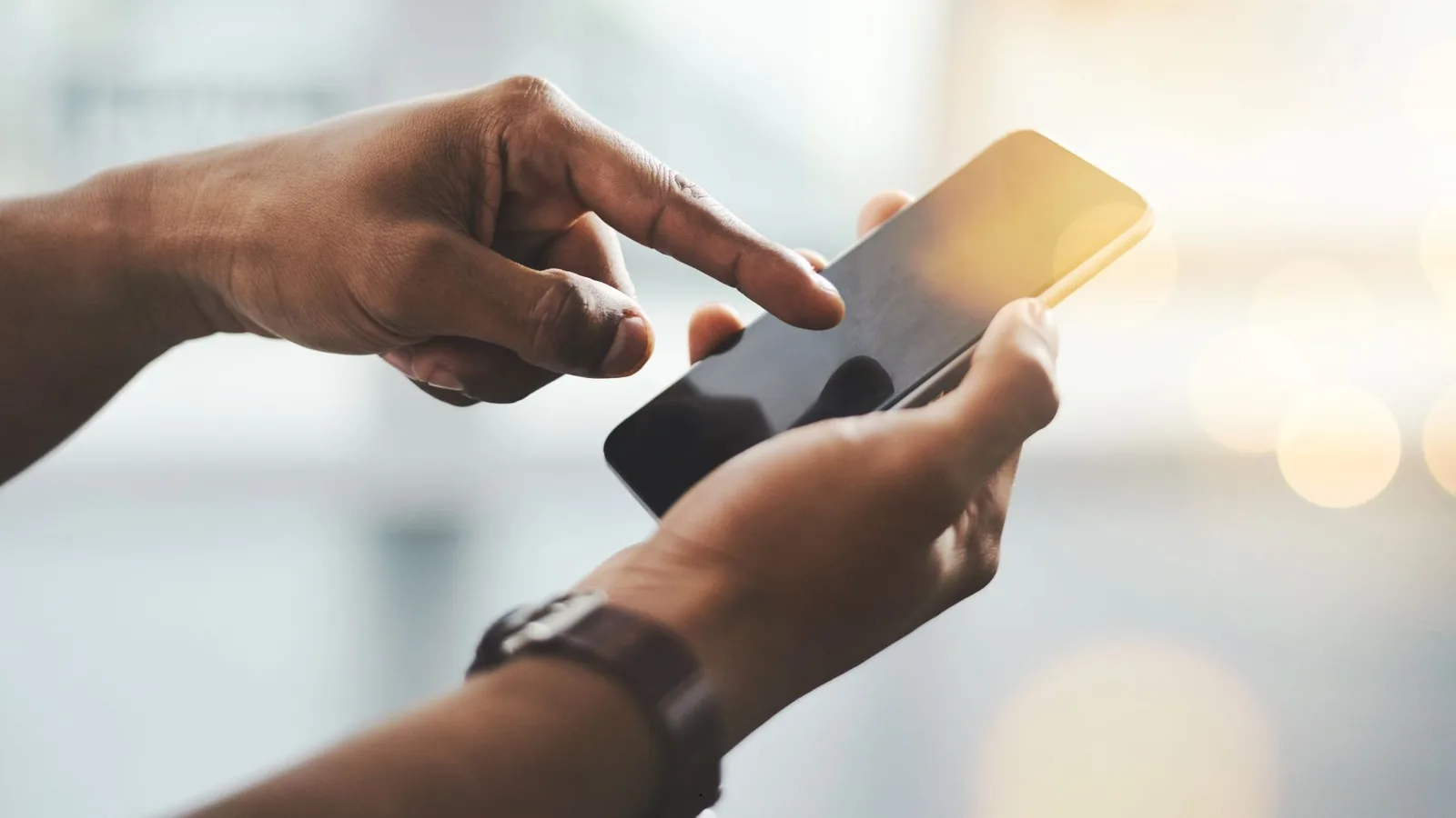 Hands using a mobile phone